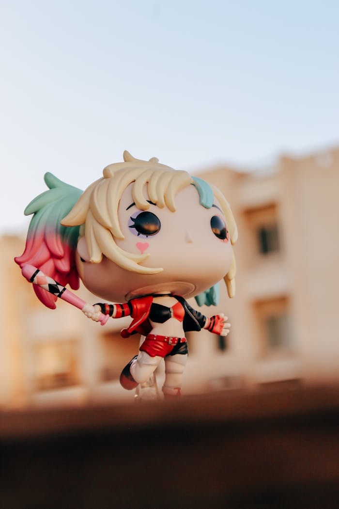 Mastering the First Impression: Your intriguing post title goes here Vibrant figure toy with pink and green hair in an urban setting at sunset.