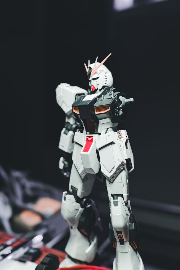 Close-up of a detailed white mecha robot action figure on display indoors.