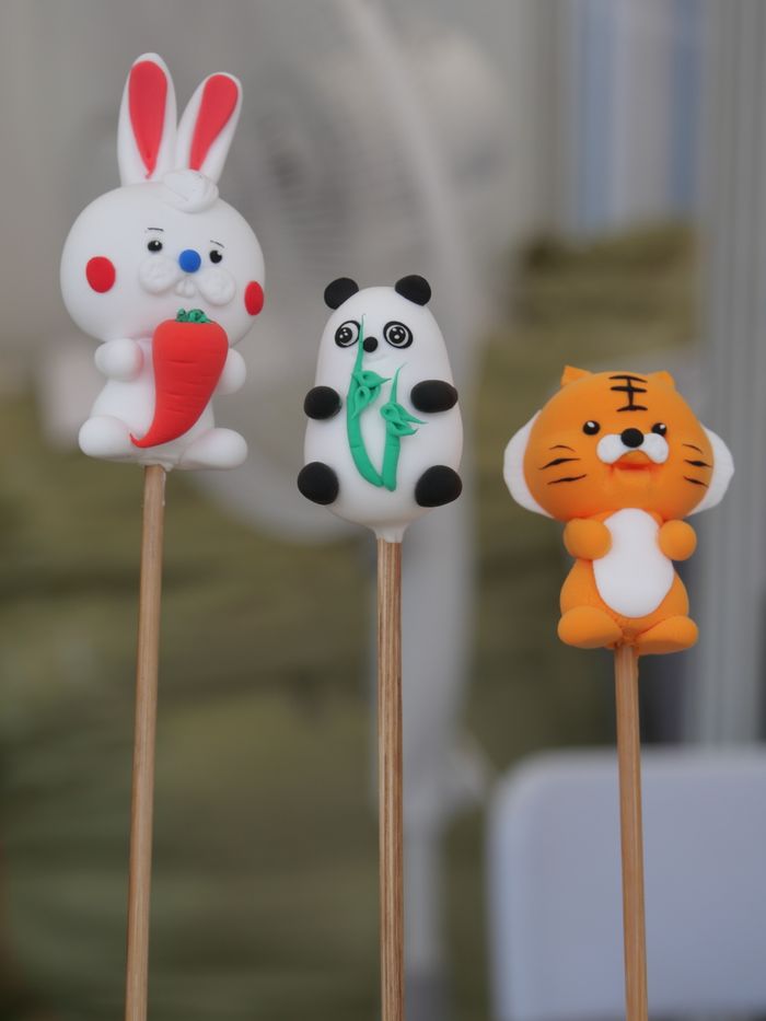 Close-up view of adorable candy sticks shaped like a panda, rabbit, and tiger. Perfect for sweet-themed designs.