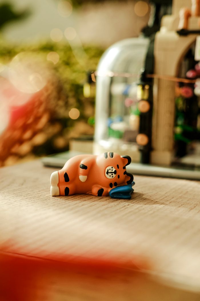 Adorable toy tiger lying on a wooden table indoors, perfect decor for children's rooms.